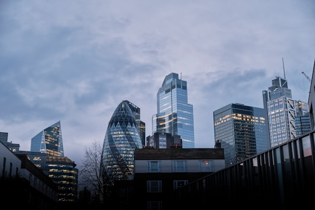 A ground-level view of central London’s skyline under a cloudy sky. The unique shape of The Gherkin building stands out amongst the line of skyscrapers. Image at LondonOfficeSpace.com.